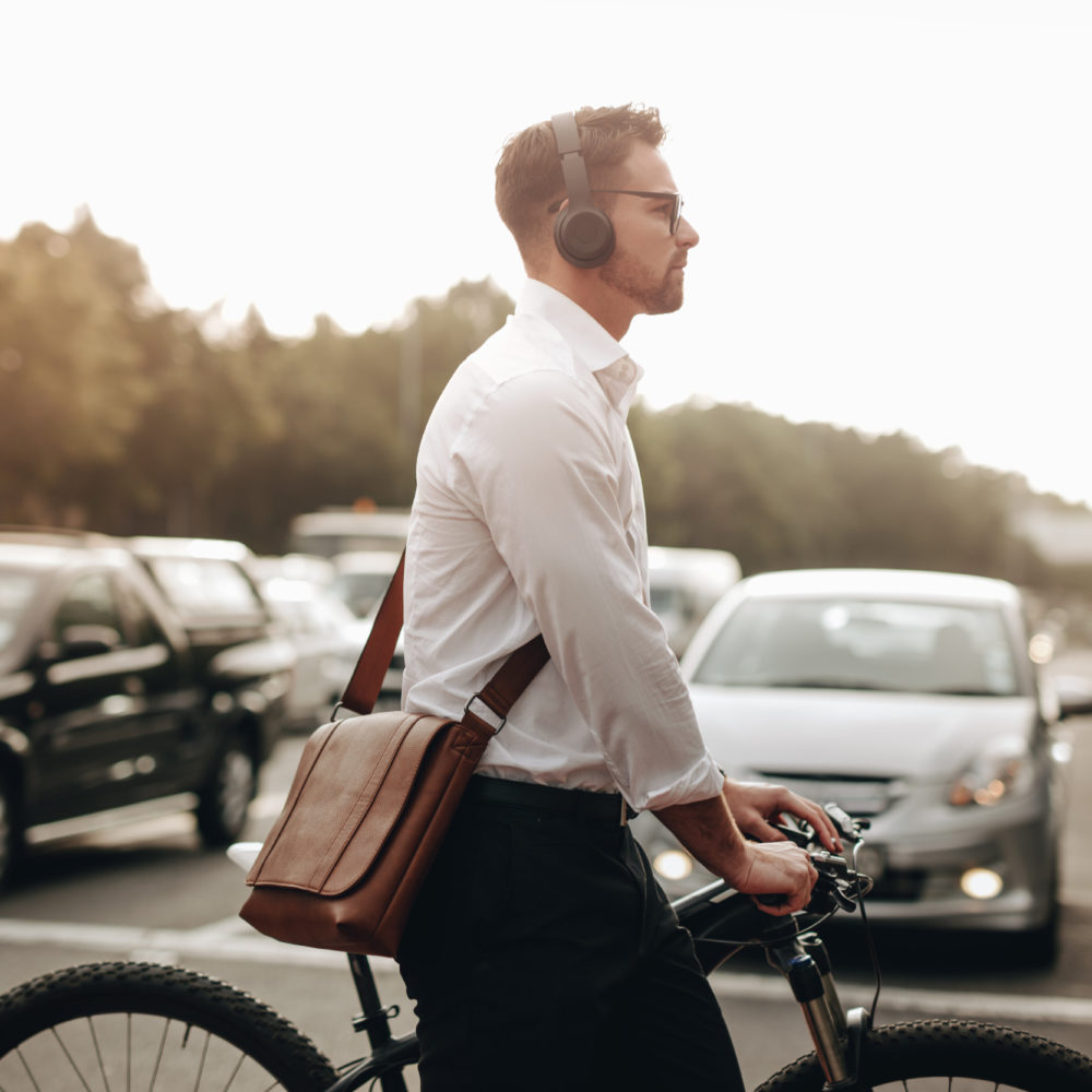 En man på en cykel som har på sig hörlurar